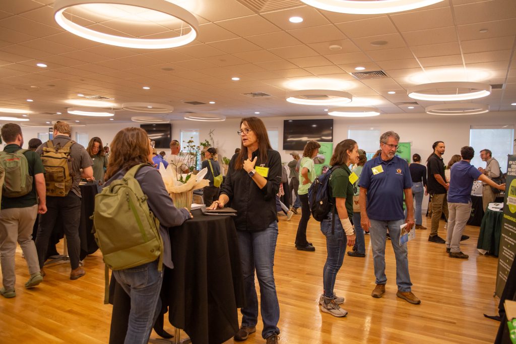 people standing around talking to each other at an event.